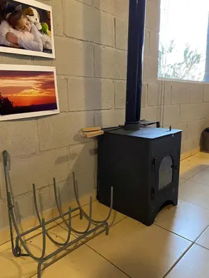 a wood stove in a room with a wall at Alma Tierra in Merlo