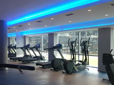 a gym with a row of treadmills in a building at Epic Hotel Villa de Merlo in Merlo