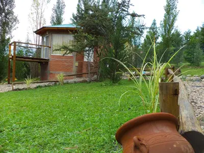 a fire hydrant in a yard next to a house at Cabañas Kumelkalechi in Los Reartes