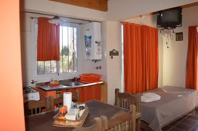 a kitchen with a table and a sink in a room at Cabañas Kumelkalechi in Los Reartes