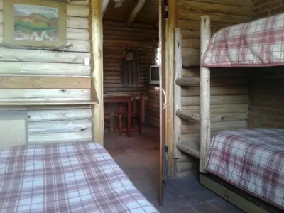 a room with two bunk beds in a log cabin at Cabañas Quisama in Nono