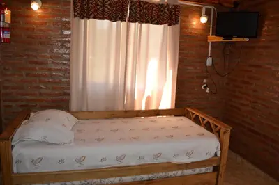 a bed in a room with a window at Der Wald cabañas in Los Reartes