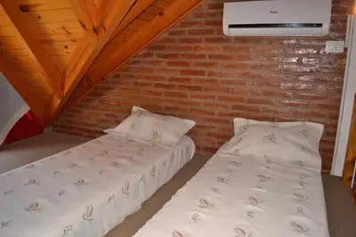 two beds in a room with a brick wall at Der Wald cabañas in Los Reartes
