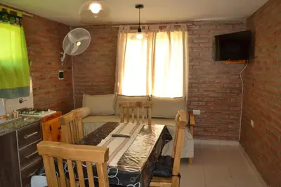 a kitchen and dining room with a table and a couch at Der Wald cabañas in Los Reartes