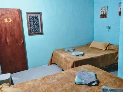 two beds in a room with blue walls at Residencial Marluc in Río Cuarto