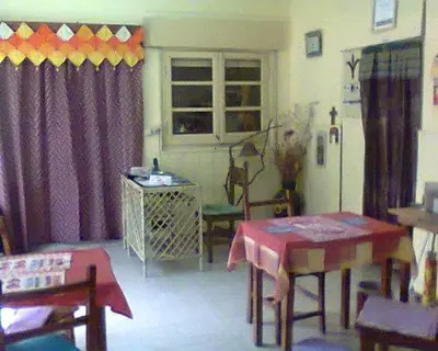 a living room with a table and a refrigerator at Residencial Marluc in Río Cuarto