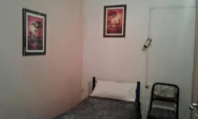 a room with a chair and a white wall at Residencial Marluc in Río Cuarto