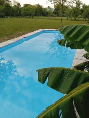 a swimming pool with blue water in a field at Casas Tierra de Ensueno in Villa Parque Siquiman