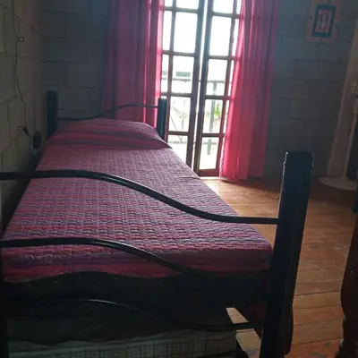 a bed sitting in a room with a window at Casas Tierra de Ensueno in Villa Parque Siquiman