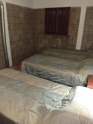 a group of three beds in a room at Casas Tierra de Ensueno in Villa Parque Siquiman
