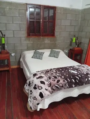 a bedroom with a bed with a blanket on it at Casas Tierra de Ensueno in Villa Parque Siquiman