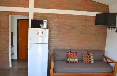 a living room with a couch and a brick wall at Isabel in Alta Gracia