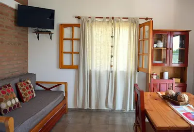 a living room with a couch and a table and a window at Isabel in Alta Gracia