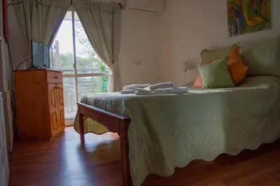 a bedroom with a bed with a television and a window at Cabaña Su Estar in Villa de Las Rosas