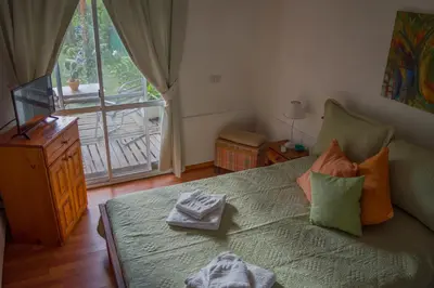a bedroom with a bed and a window with a balcony at Cabaña Su Estar in Villa de Las Rosas