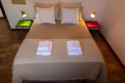 a bedroom with a bed with two towels on it at Bandera Blanca Cabañas & Suites in San Javier
