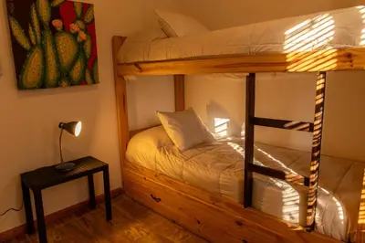 a bedroom with a bunk bed and a lamp at Bandera Blanca Cabañas & Suites in San Javier