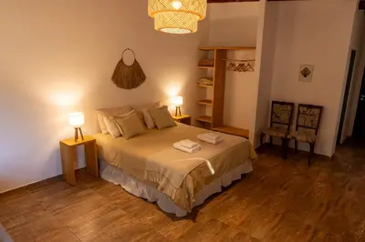 a bedroom with a bed with two lamps on it at Bandera Blanca Cabañas & Suites in San Javier