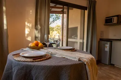 a table with two plates and wine glasses on it at Bandera Blanca Cabañas & Suites in San Javier