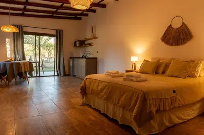 a bedroom with a bed and a table with a dining room at Bandera Blanca Cabañas & Suites in San Javier