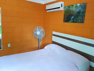 a bedroom with a white bed and a fan at Residencia Jose Maria in Santa Rosa de Calamuchita