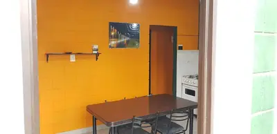a kitchen with a table and a yellow wall at Residencia Jose Maria in Santa Rosa de Calamuchita