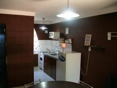 a kitchen with a white refrigerator and a table at Residencia Jose Maria in Santa Rosa de Calamuchita