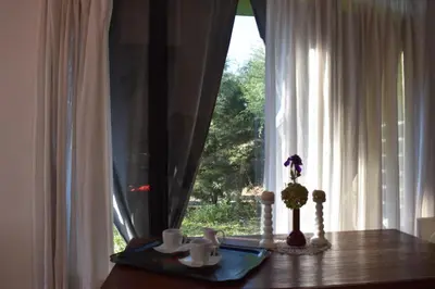 a table with cups and a vase on top of a window at Celandine in Los Reartes