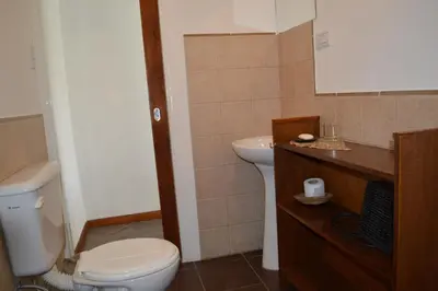 a bathroom with a white toilet and a sink at Celandine in Los Reartes