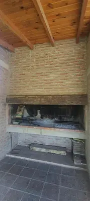 a fireplace in a room with a brick wall at El Campito casa frente al río in Villa Carlos Paz