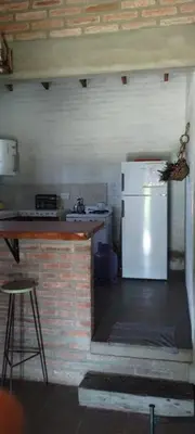 a kitchen with a white refrigerator and a counter at El Campito casa frente al río in Villa Carlos Paz
