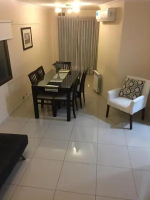 a living room with a dining room table and chairs at Chacabuco Park in Cordoba
