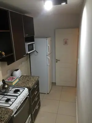 a kitchen with a stove and a white refrigerator at Chacabuco Park in Cordoba