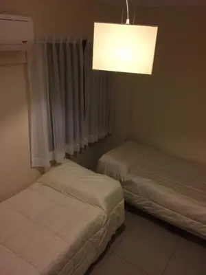 a bedroom with two beds and a light fixture at Chacabuco Park in Cordoba