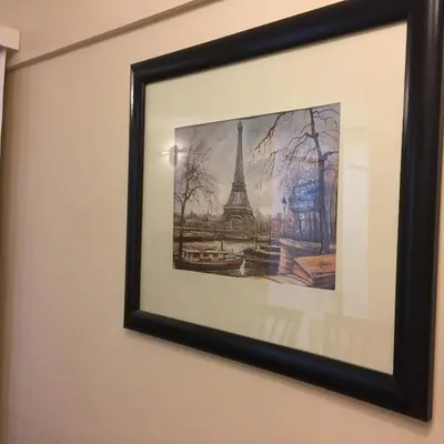 a framed picture of the eiffel tower on a wall at Chacabuco Park in Cordoba