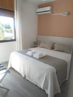 a bedroom with a white bed with towels on it at Casa Piedra Hotel in Villa Carlos Paz