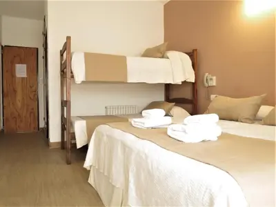 two beds in a room with two bunk beds at Casa Piedra Hotel in Villa Carlos Paz