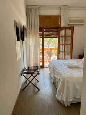 a bedroom with a bed and a door to a balcony at Casa Piedra Hotel in Villa Carlos Paz
