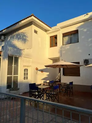 a house with a patio with tables and umbrellas at Casa Piedra Hotel in Villa Carlos Paz