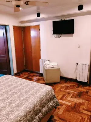 a bedroom with a bed and a flat screen tv at Hotel Petit in Cordoba
