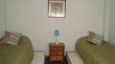 a bedroom with two beds and a table with a lamp at Departamento sobre principal calle PEATONAL plena zona Finaciera y Comercial in Cordoba