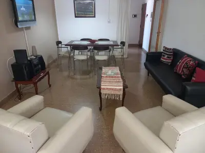 a living room with couches and a tv and a table at Departamento sobre principal calle PEATONAL plena zona Finaciera y Comercial in Cordoba