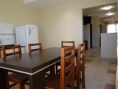 a kitchen with a table and chairs and a refrigerator at Apart Hotel Vista San Lucas in Carpintería