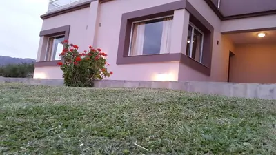 a house with a lawn in front of it at Apart Hotel Vista San Lucas in Carpintería