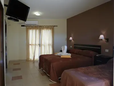 a hotel room with two beds and a flat screen tv at Apart Hotel Vista San Lucas in Carpintería