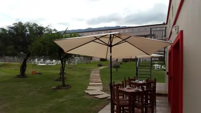 a table with an umbrella next to a building at Apart Hotel Vista San Lucas in Carpintería