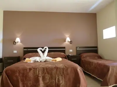 a hotel room with two beds with towels at Apart Hotel Vista San Lucas in Carpintería