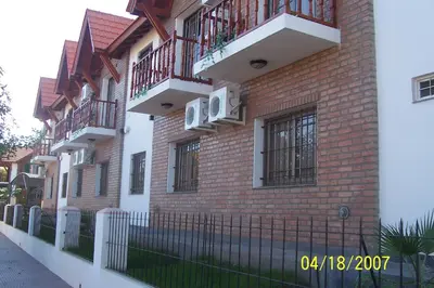 a brick building with balconies on the side of it at Apart Hotel Piscu Yaco in Merlo