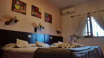 a bedroom with two beds and a window at Apart Hotel Piscu Yaco in Merlo