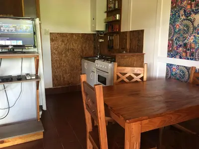 a kitchen with a wooden table and a stove at Sol de Bach in Tanti